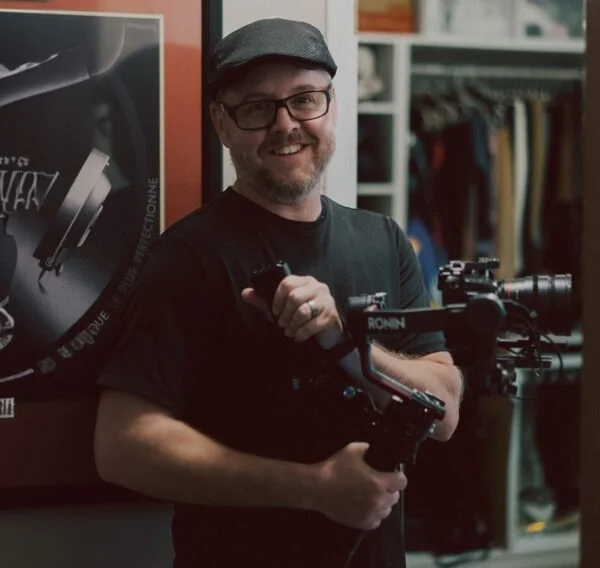Professional videographer operating a camera stabilizer during an event video production shoot for corporate video content.